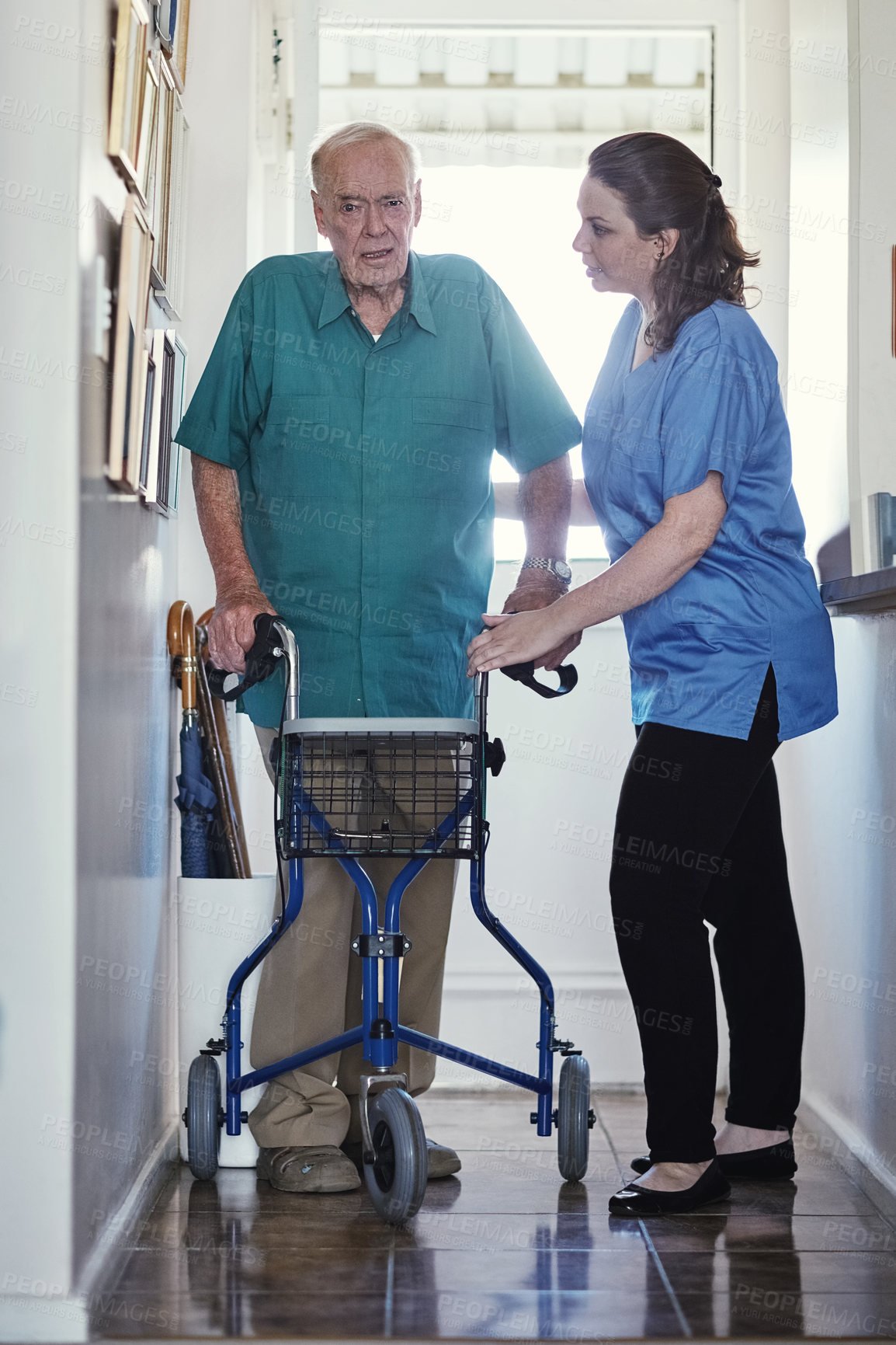 Buy stock photo Shot of a female nurse assisting her senior patient who's using a walker for support