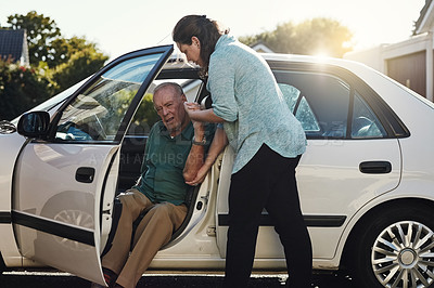 Buy stock photo Shot of a woman helping her senior father out the car