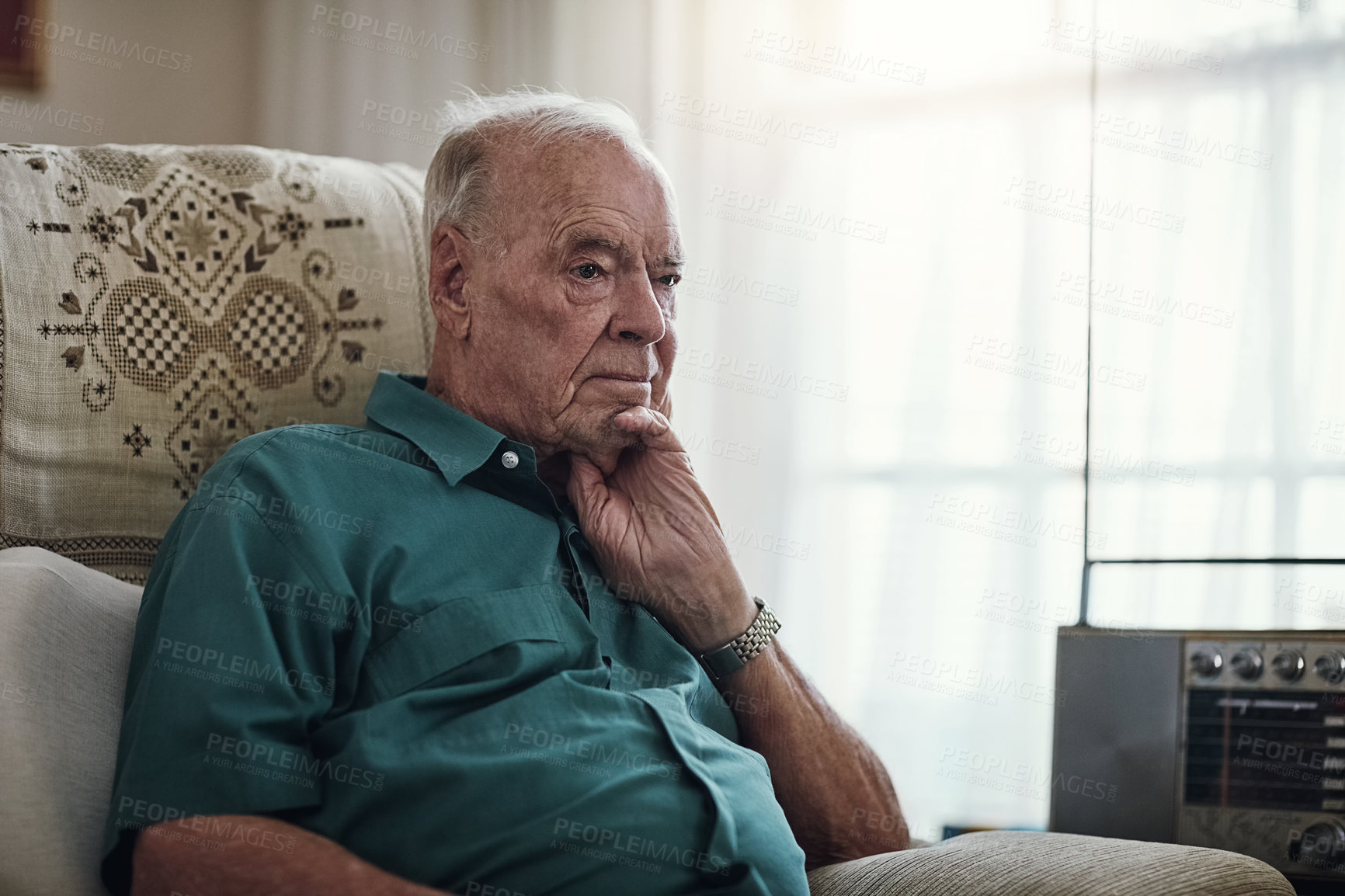 Buy stock photo Cropped shot of a senior man sitting by himself in a living room