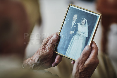 Buy stock photo Cropped shot of a senior man staring at a old wedding picture