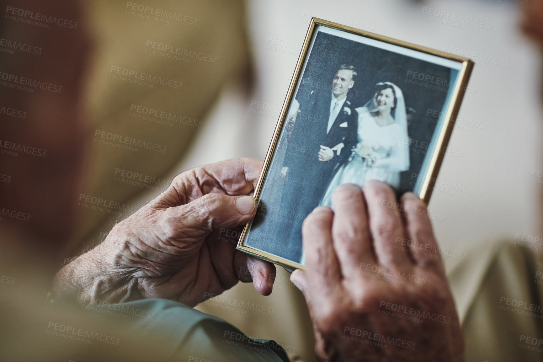Buy stock photo Cropped shot of a senior man staring at a old wedding picture