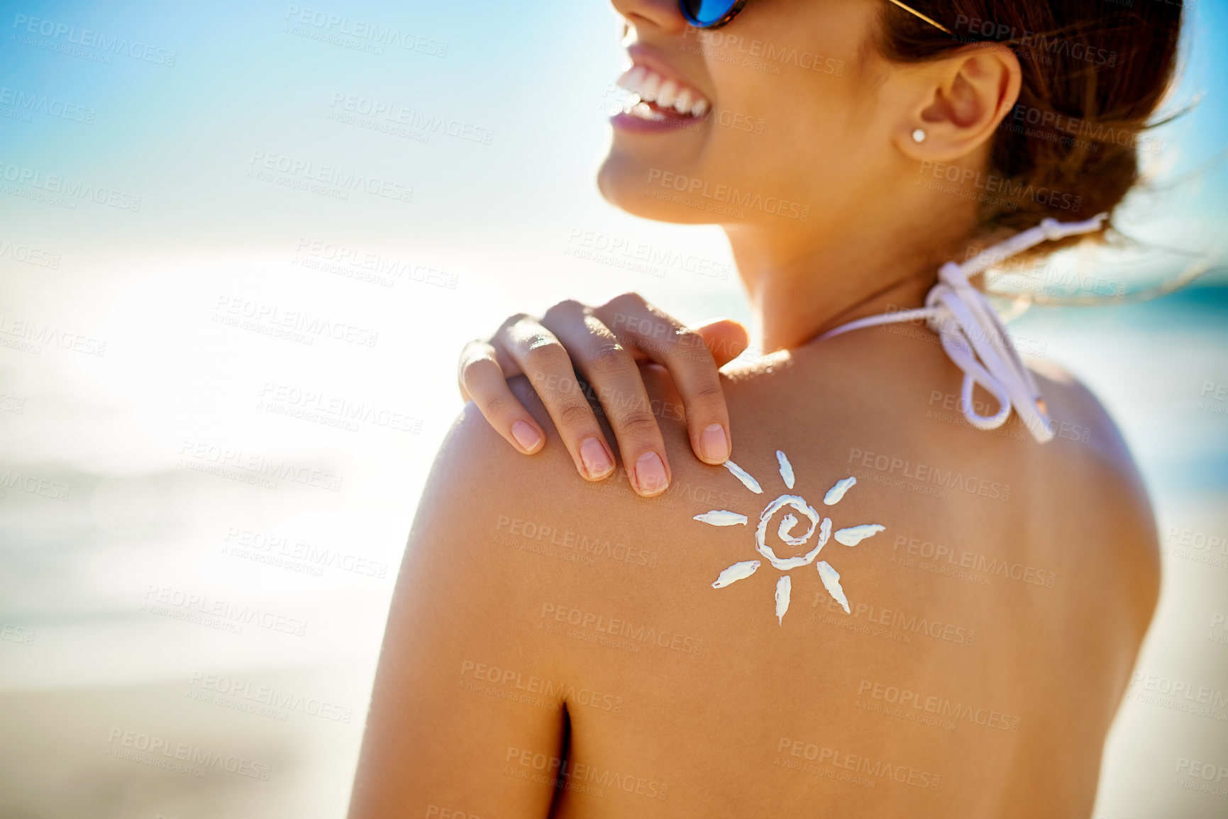 Buy stock photo Cropped shot of a young woman posing with suntan lotion on her shoulder