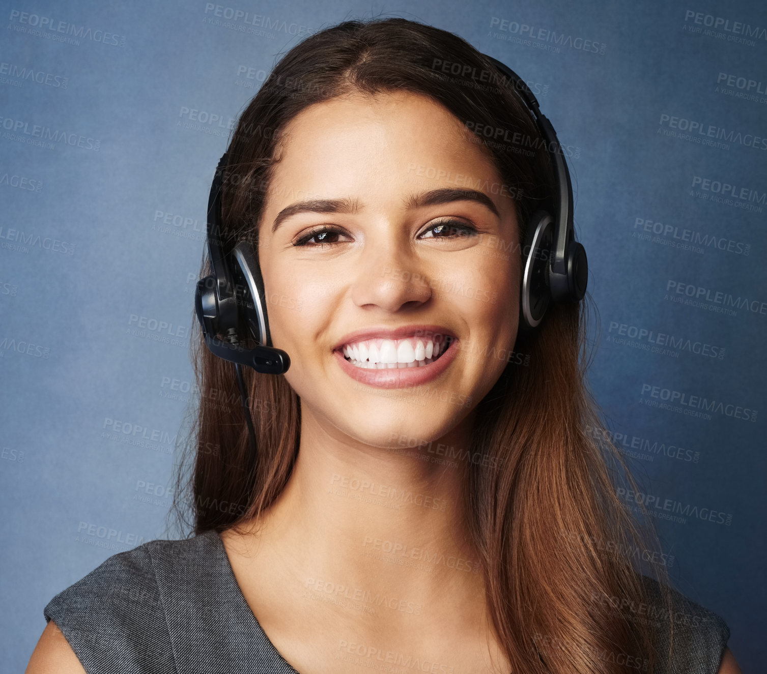 Buy stock photo Studio portrait of a professional young woman wearing a headset against a gray background