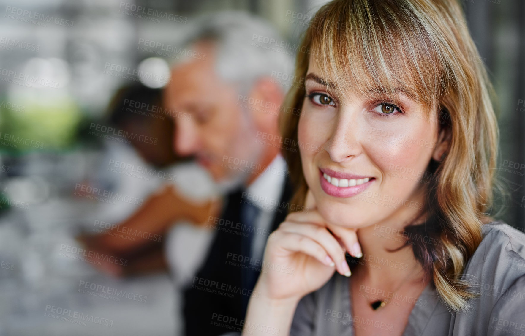 Buy stock photo Portrait of a businesswoman sitting in a boardroom meeting with colleagues blurred in the background