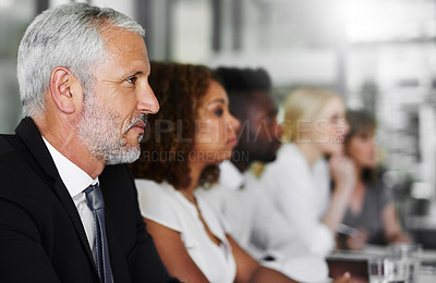 Buy stock photo Shot of a group of businesspeople sitting in a boardroom meeting