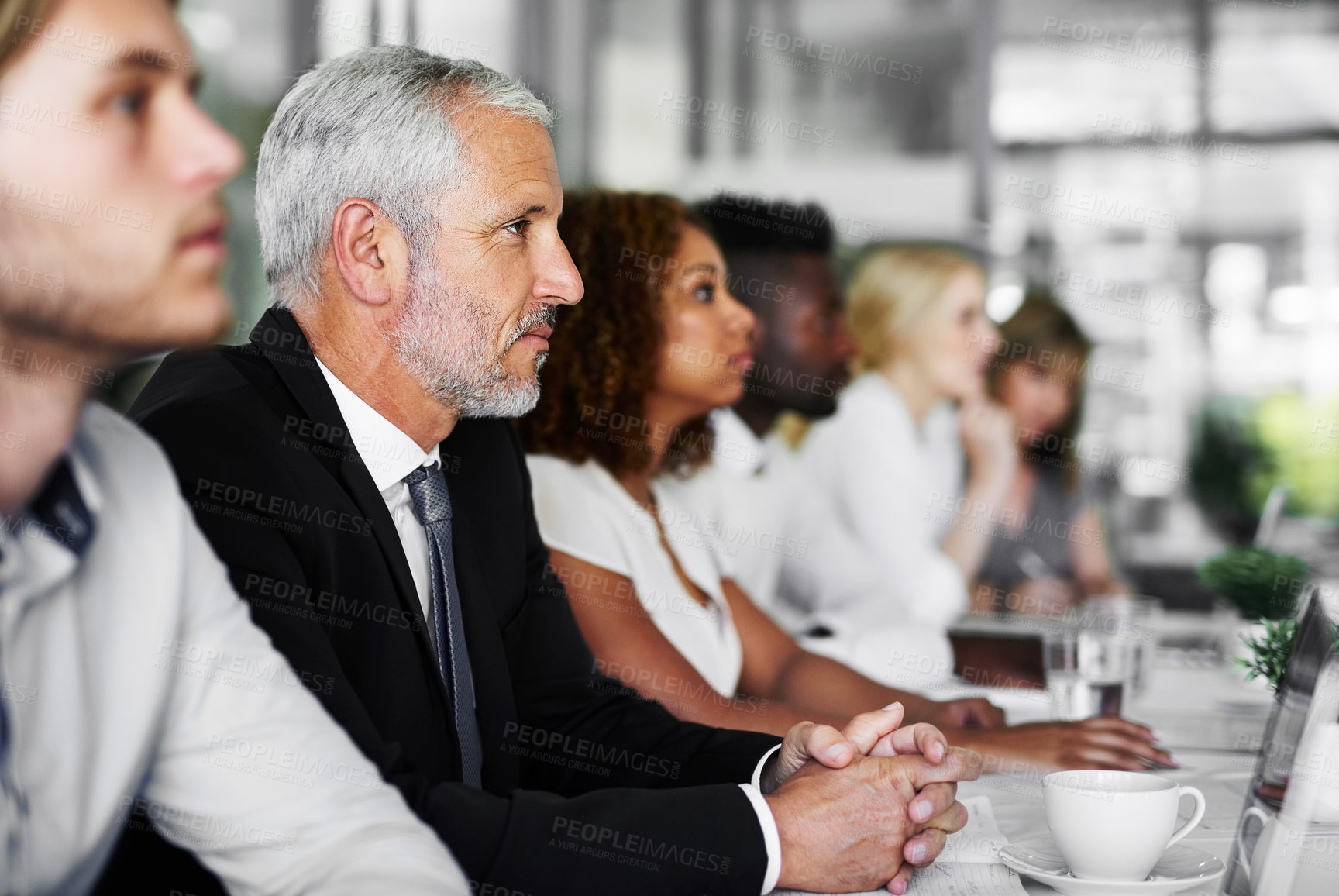 Buy stock photo Shot of a group of businesspeople sitting in a boardroom meeting