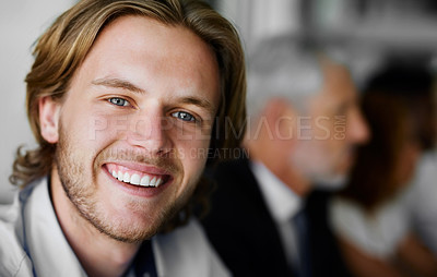 Buy stock photo Portrait of a businessman sitting in a boardroom meeting with colleagues blurred in the background