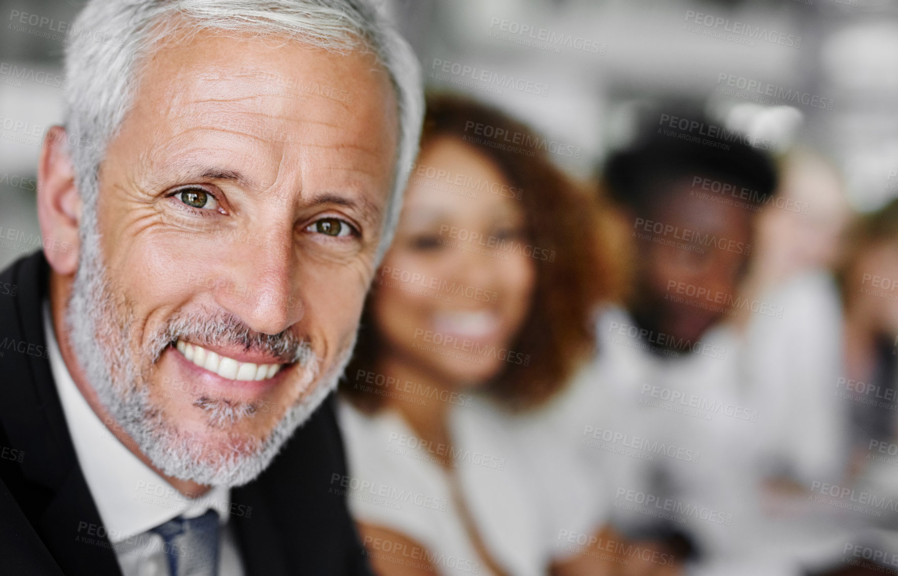 Buy stock photo Portrait of a businessman sitting in a boardroom meeting with colleagues blurred in the background