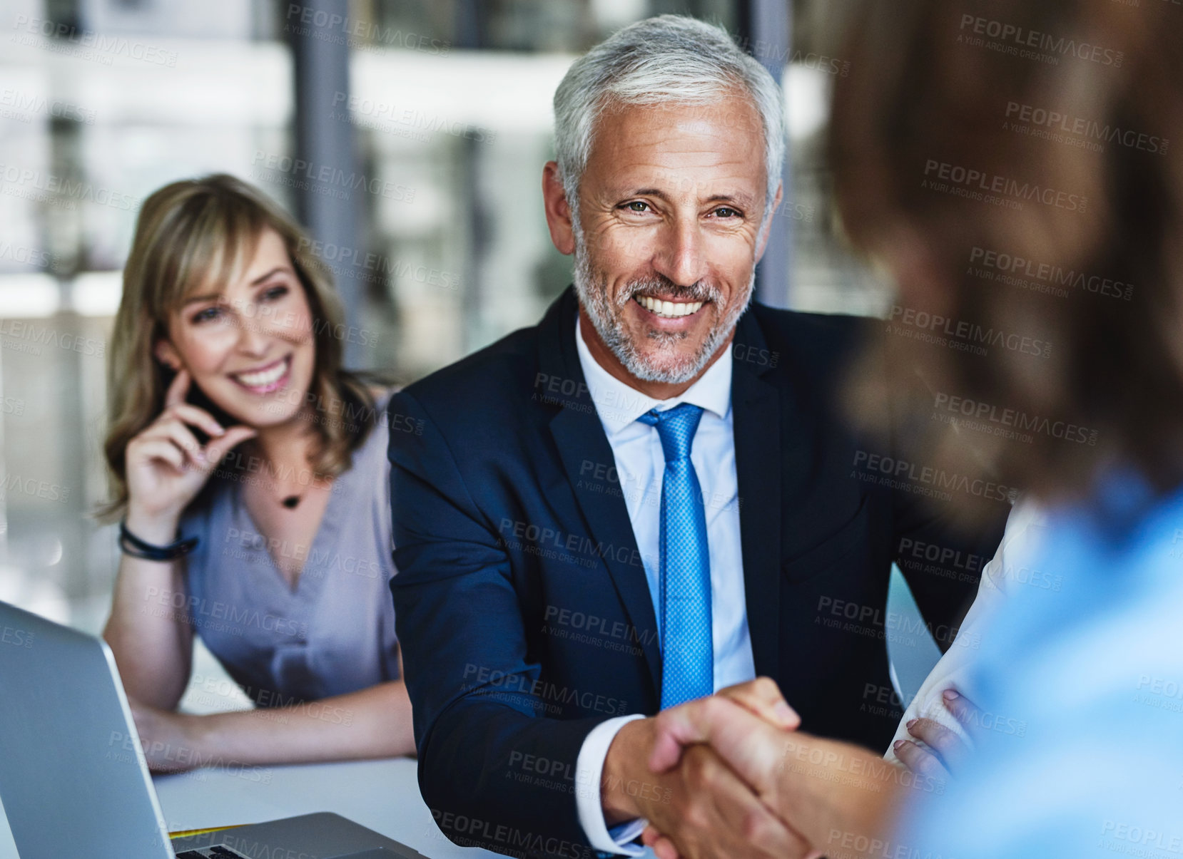 Buy stock photo Shot of businessmen shaking hands during a meeting at work