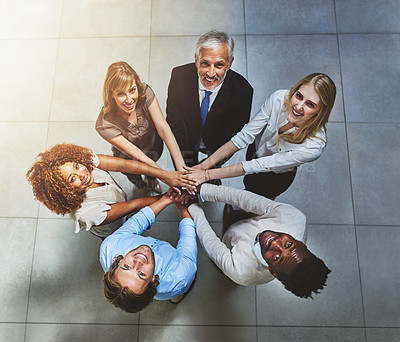 Buy stock photo High angle shot of a group of colleagues joining their hands in solidarity