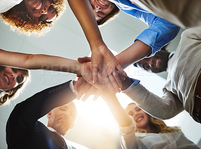 Buy stock photo Low angle shot of a group of colleagues joining their hands in solidarity