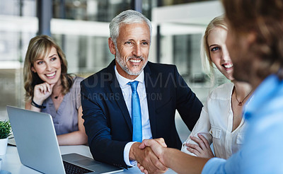 Buy stock photo Shot of businessmen shaking hands during a meeting at work