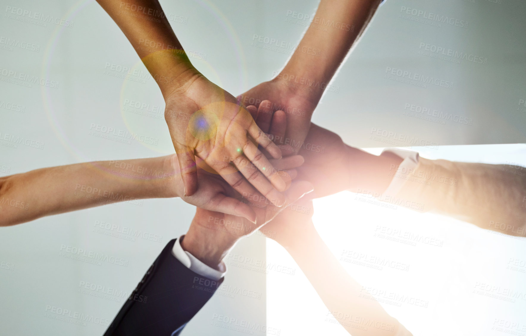 Buy stock photo Low angle shot of a group of colleagues joining their hands in solidarity