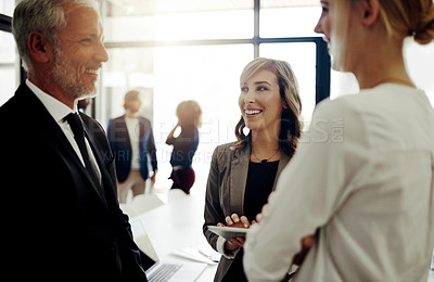 Buy stock photo Cropped shot of three businesspeople talking while standing in the office