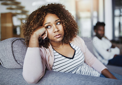 Buy stock photo Relationship issues, communication problems and divorce talk of a couple after a fight at home. Upset female feeling frustrated on a living room couch. Annoyed couple on a sitting on a sofa