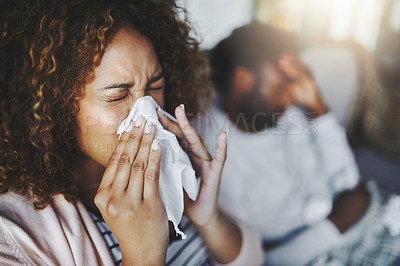 Buy stock photo Ill or sick woman with allergy, sinus infection sneezing in tissue or blowing nose during flu season at home. Sick girl caught a bad cold showing symptoms of covid, or suffering from a virus disease