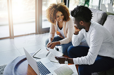 Buy stock photo Shot of a young couple going through their paperwork together at home