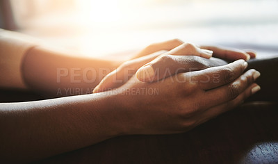 Buy stock photo Couple comforting, supporting and holding hands on a table. An African man and woman showing love, compassion and romance in a gesture of care. Human connection through touch, helps with grief.