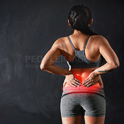 Buy stock photo Rearview shot of an unidentifiable sportswoman holding her back after injuring it