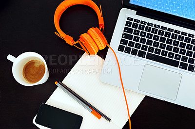 Buy stock photo High angle shot of an empty workspace with a laptop, earphones and notebook arranged on it
