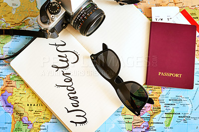 Buy stock photo High angle shot of a map with a notebook, camera and passport arranged on it