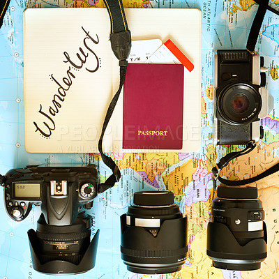Buy stock photo High angle shot of a map with a passport and various cameras and lenses arranged on it