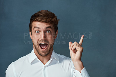 Buy stock photo Portrait, wow and idea with a man pointing in studio on a blue background during a lightbulb moment. Face, surprise and eureka with an excited young male person looking shocked or amazed by good news