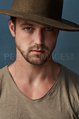 Buy stock photo Studio portrait of a handsome young man wearing a hat against a dark background