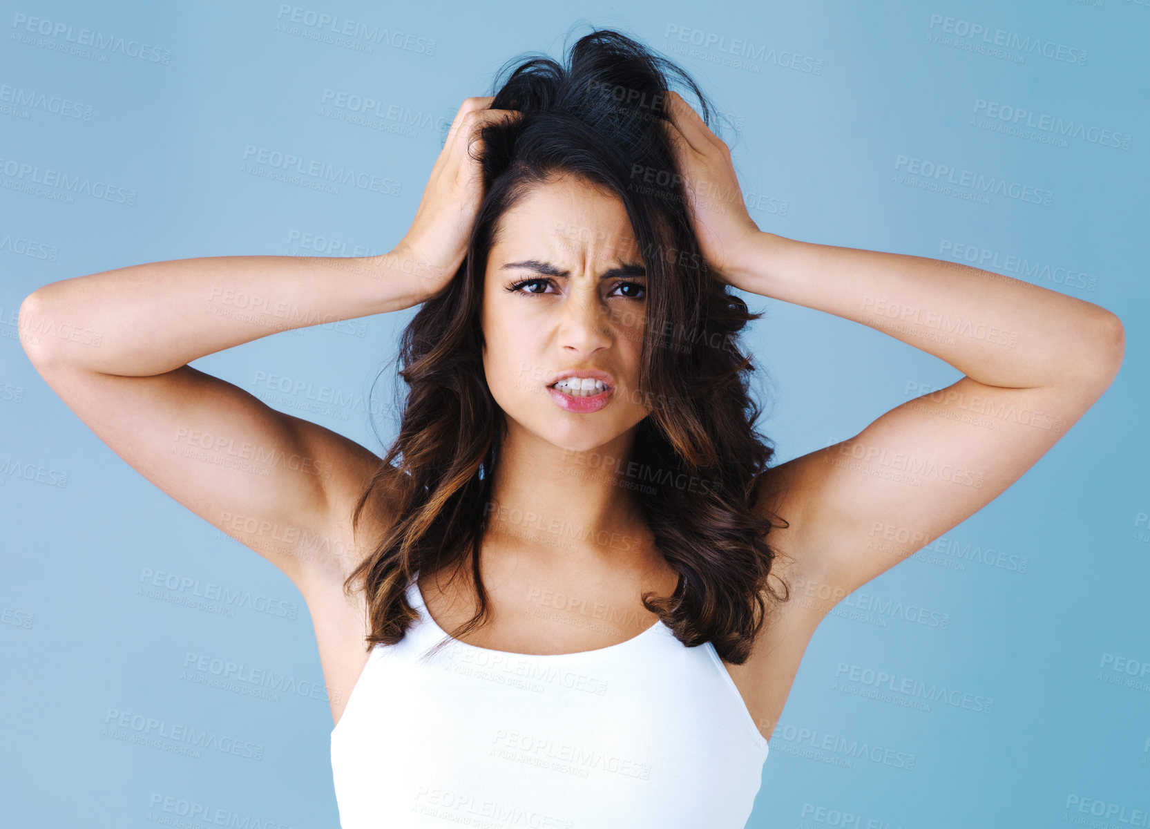 Buy stock photo Woman, frustrated and hair care in studio portrait with mess, angry or cosmetics by blue background. Girl, shock and confused for hairstyle with bad results, stress or crisis for change with disaster