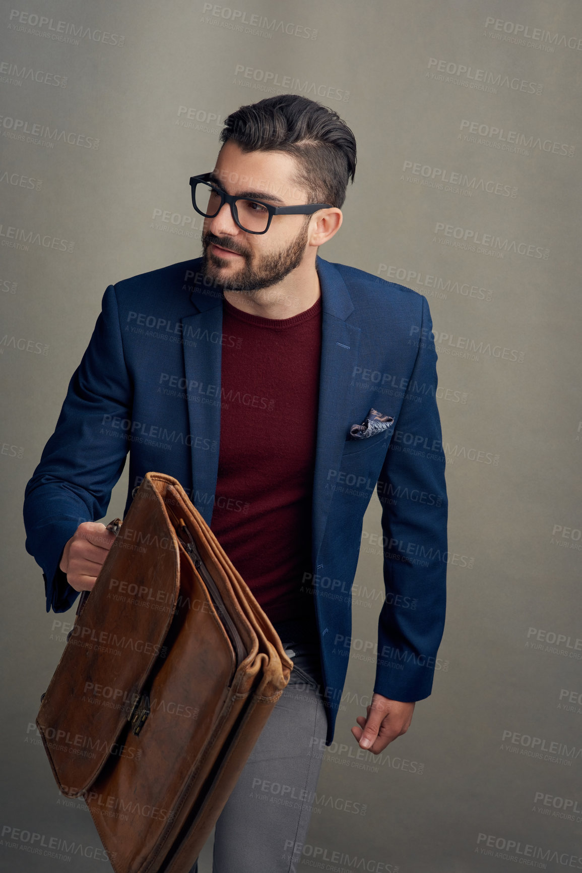 Buy stock photo Studio shot of a handsome young man carrying a bag against a grey background