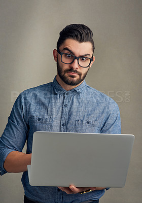 Buy stock photo Studio shot of a handsome young man looking shocked while using a laptop against a grey background