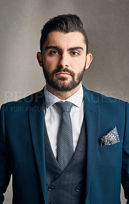 Buy stock photo Studio portrait of a stylishly dressed and confident young businessman posing against a grey background