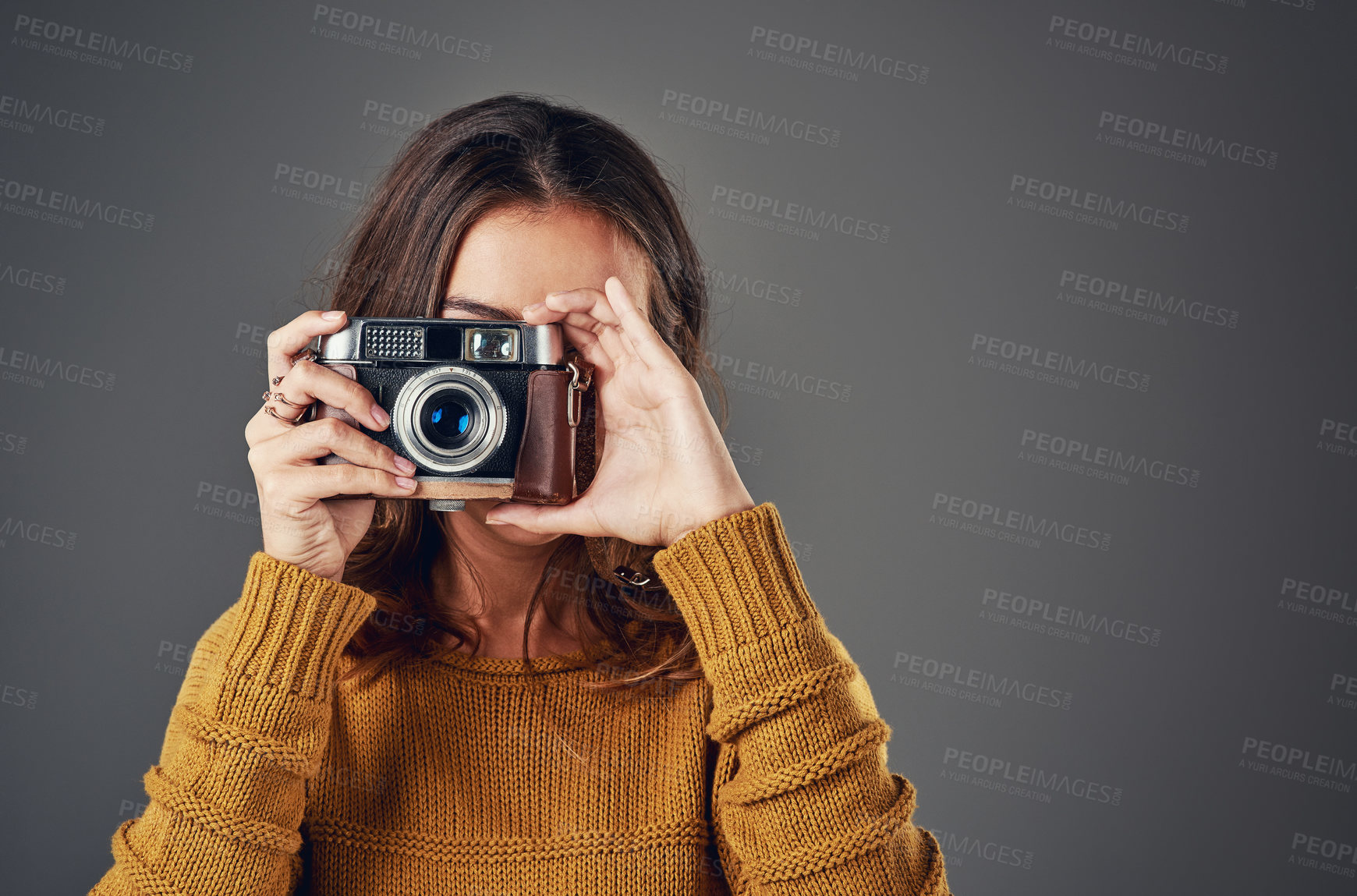 Buy stock photo Portrait of an attractive young woman taking photographs against a grey background