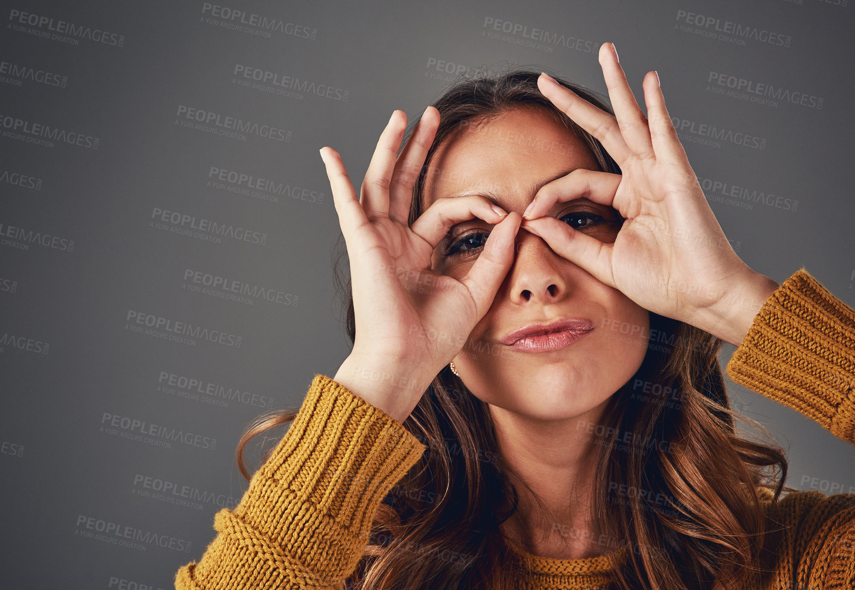 Buy stock photo Woman, portrait and binocular hands in studio with comedy action, feeling goofy and meme face for play. Model, happy and ok emoji for positive review, agreement and sign language by gray background