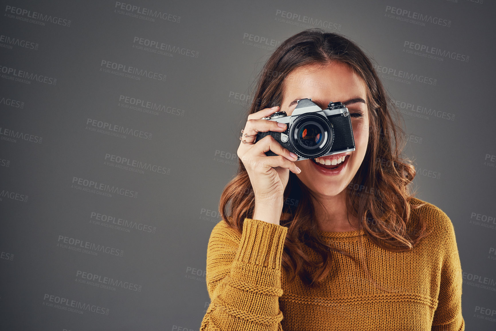 Buy stock photo Portrait of an attractive young woman taking photographs against a grey background