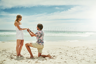 Buy stock photo Full length shot of a young man proposing to his girlfriend on the beach