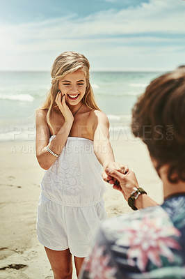 Buy stock photo Cropped shot of a young man proposing to his girlfriend on the beach