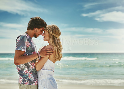 Buy stock photo Cropped shot of an affectionate young couple embracing on the beach