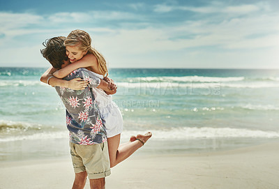 Buy stock photo Cropped shot of an affectionate young couple embracing on the beach