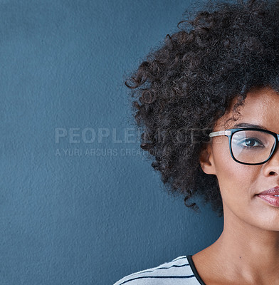 Buy stock photo Cropped studio portrait of an attractive young wearing glasses against a blue background
