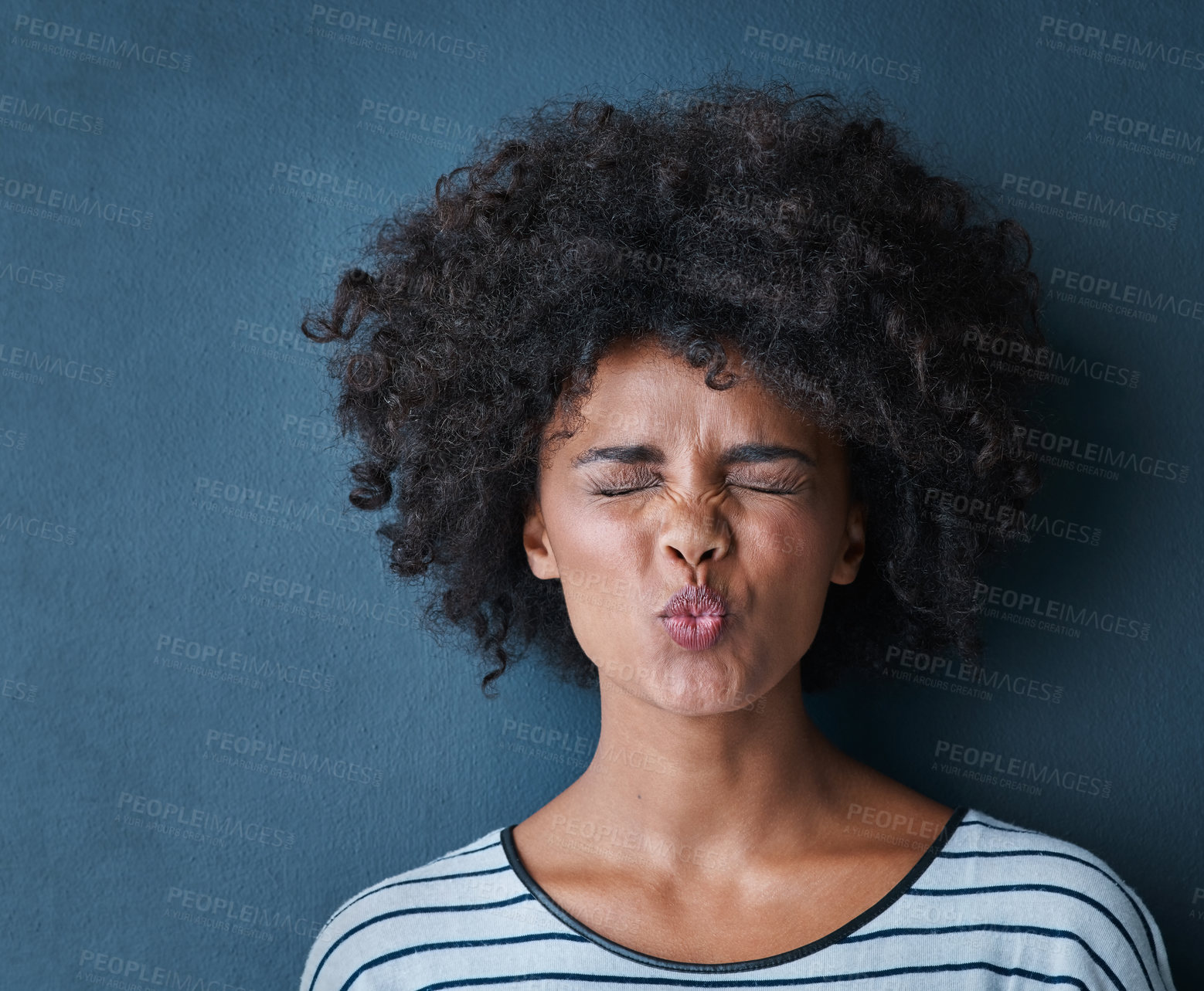 Buy stock photo Portrait, emoji and lady with kissing expression in studio for fun, relax and playful attitude on blue background. Pout, comic and goofy black woman with a funny face, crazy and personality isolated