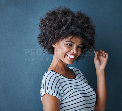 Buy stock photo Girl, portrait and pull curly hair in studio with confidence for growth, results and smile by blue background. African person, woman and model with texture, happy and change with cosmetics for afro