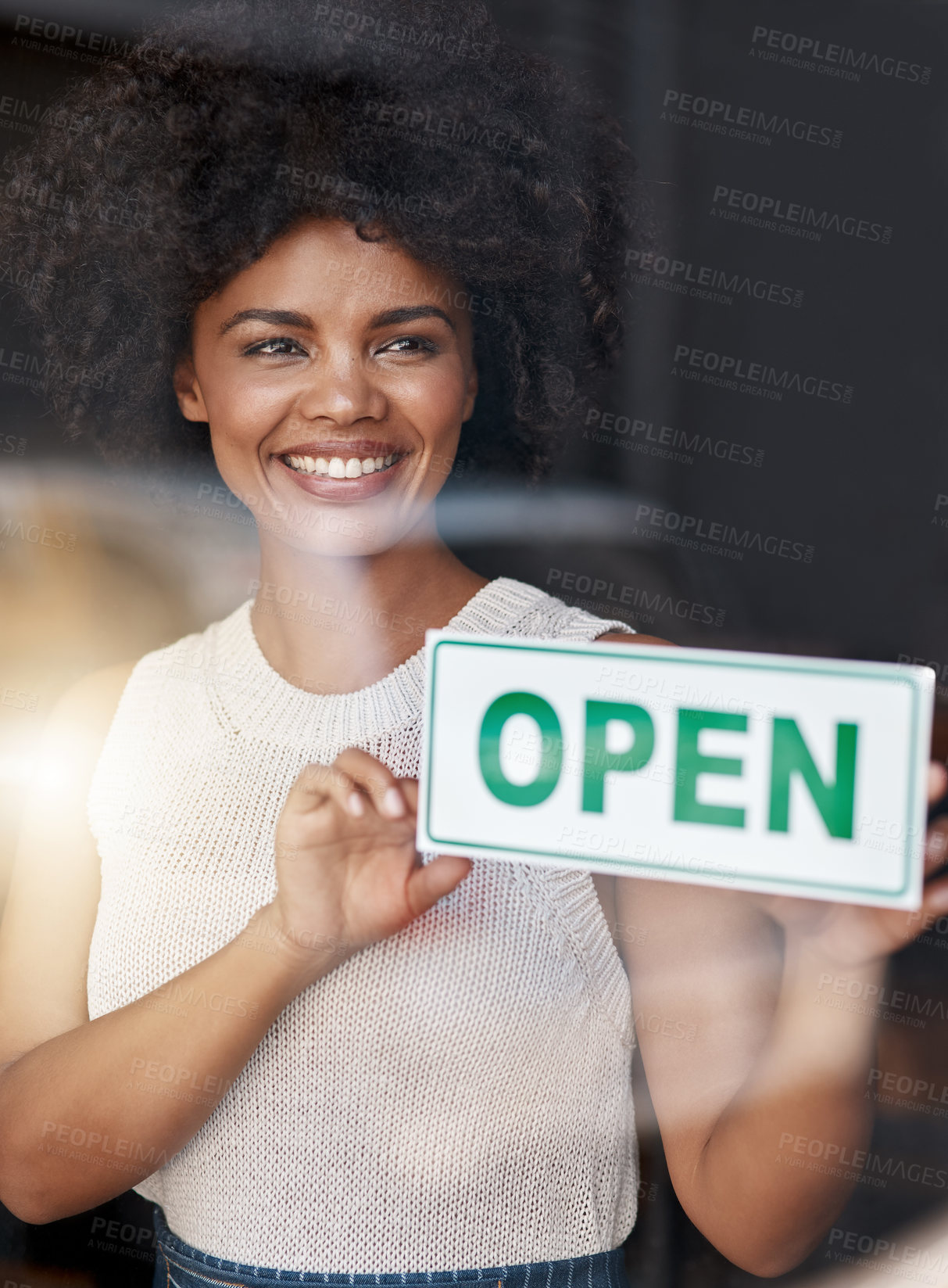 Buy stock photo Shot of a smiling young business owner holding an 