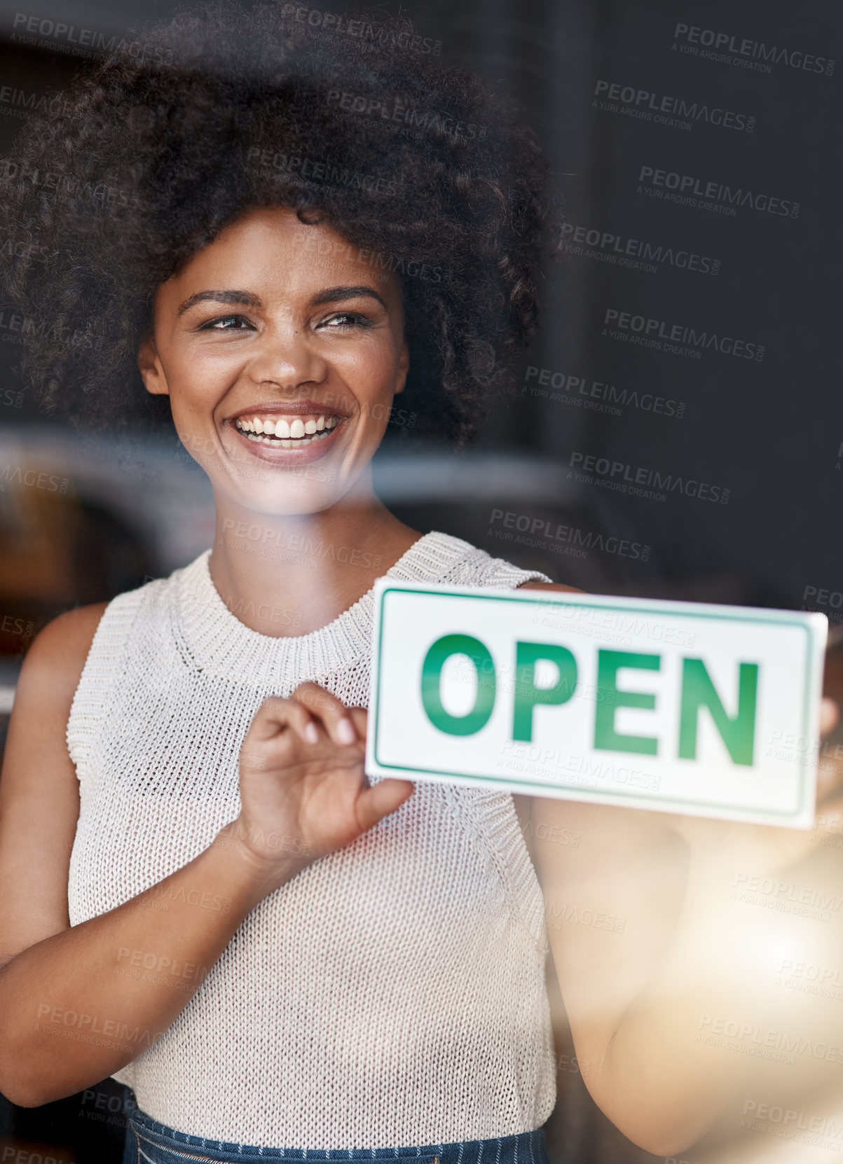 Buy stock photo Shot of a smiling young business owner holding an 