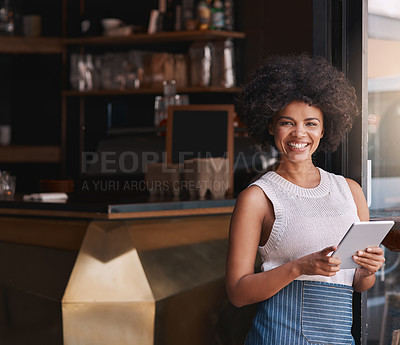 Buy stock photo Portrait of a happy young business owner using her tablet while standing inside her coffee shop