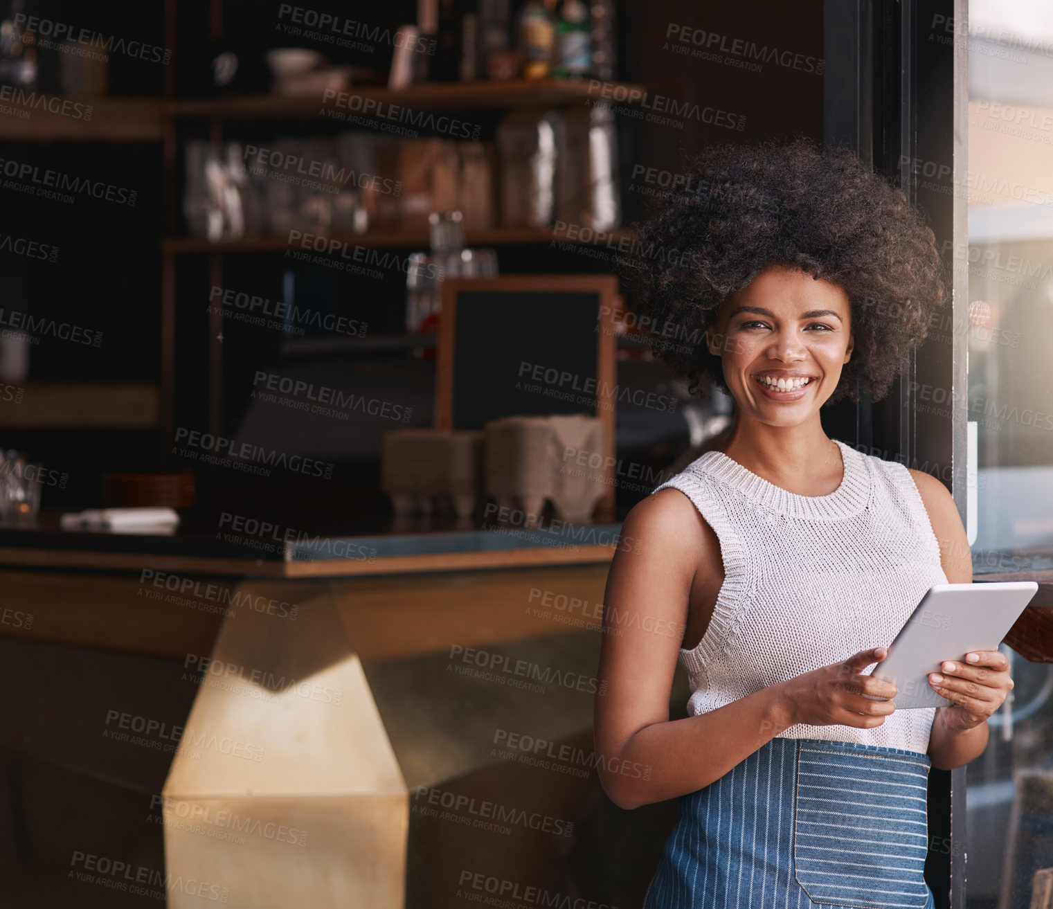 Buy stock photo Portrait of a happy young business owner using her tablet while standing inside her coffee shop