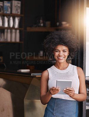 Buy stock photo Portrait of a happy young business owner using her tablet while standing inside her coffee shop