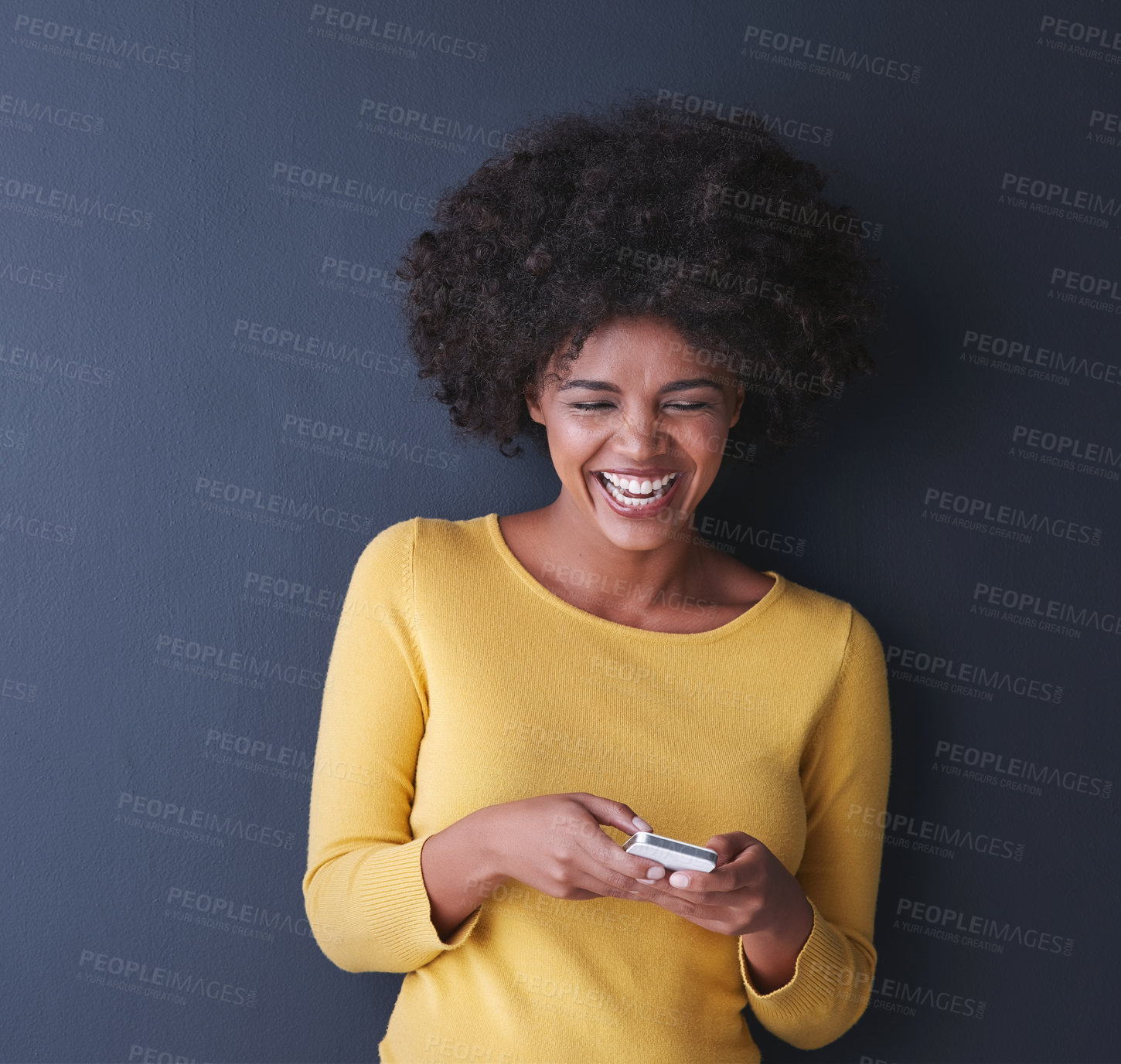 Buy stock photo Studio shot of a young woman using her phone against a grey background