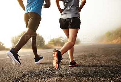 Buy stock photo Rear view shot of two sporty young people out for a run together