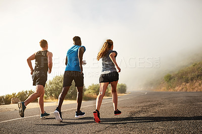 Buy stock photo Rear view shot of a group of sporty young people out for a run together